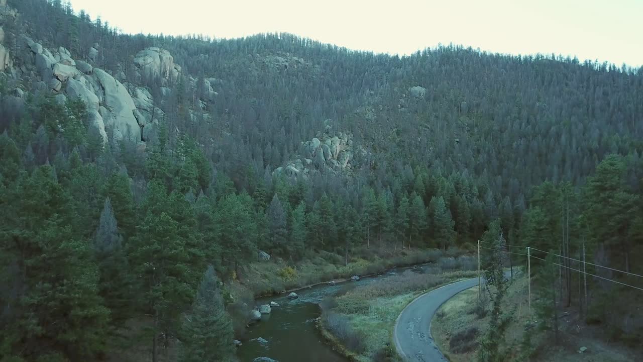 Slow rising aerial: Unique granite hillside above small mountain river