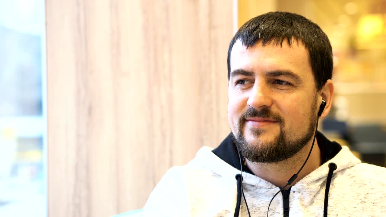 카페에서 카메라에 미소 짓는 젊은 남자.