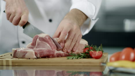 chef hands cutting meat slice in kitchen