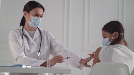 covid-19 vaccination. female doctor administering a coronavirus vaccine to a little girl.