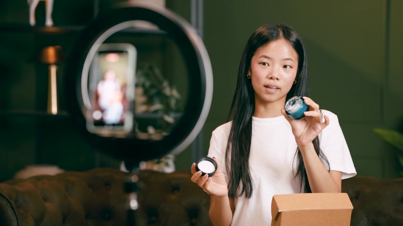 Giovane donna che registra un video di unboxing di un prodotto per la cura della pelle