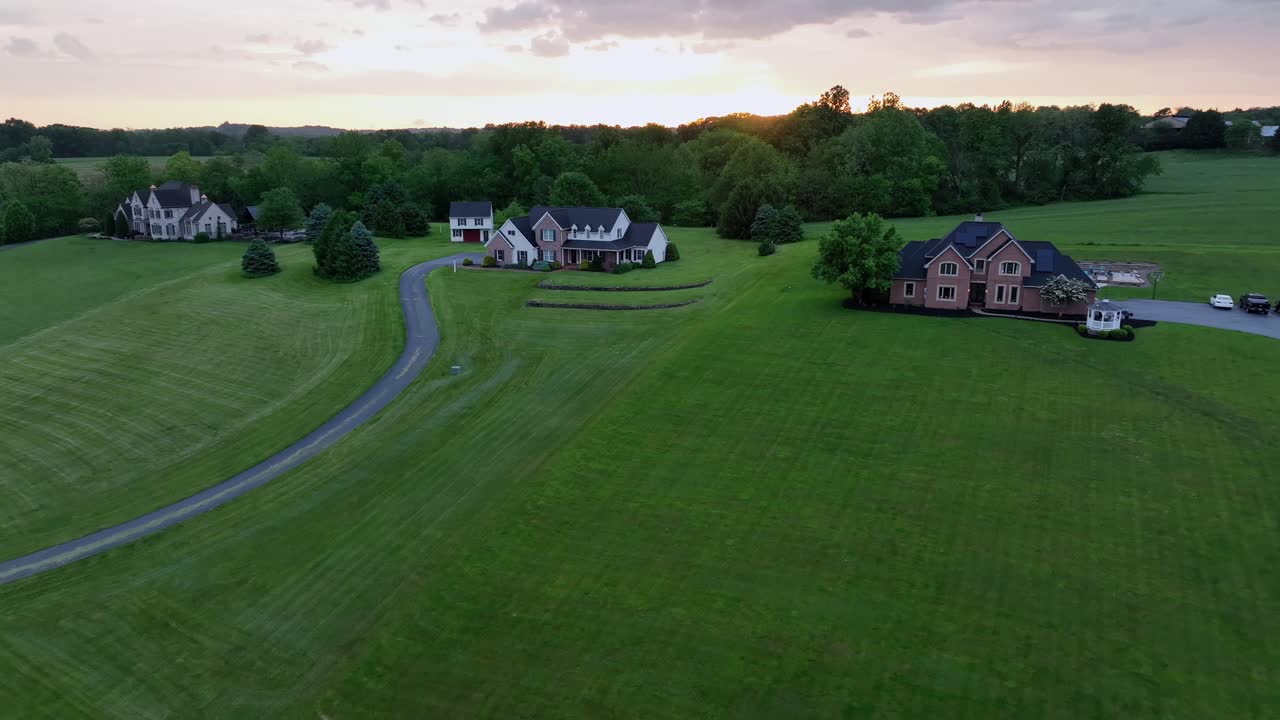 Rural American home at sunset with expansive green lawn and classic ...