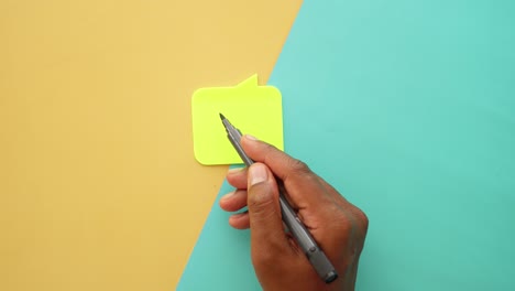 escritura a mano en una nota adhesiva amarilla