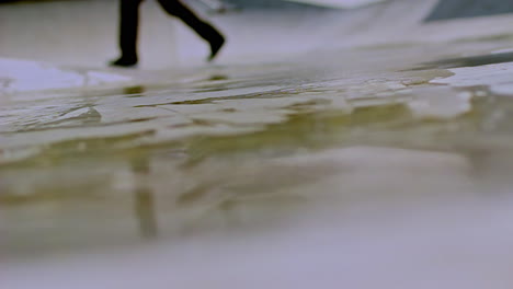 close-up of urban cleaning action with squeegee sliding over wet pavement