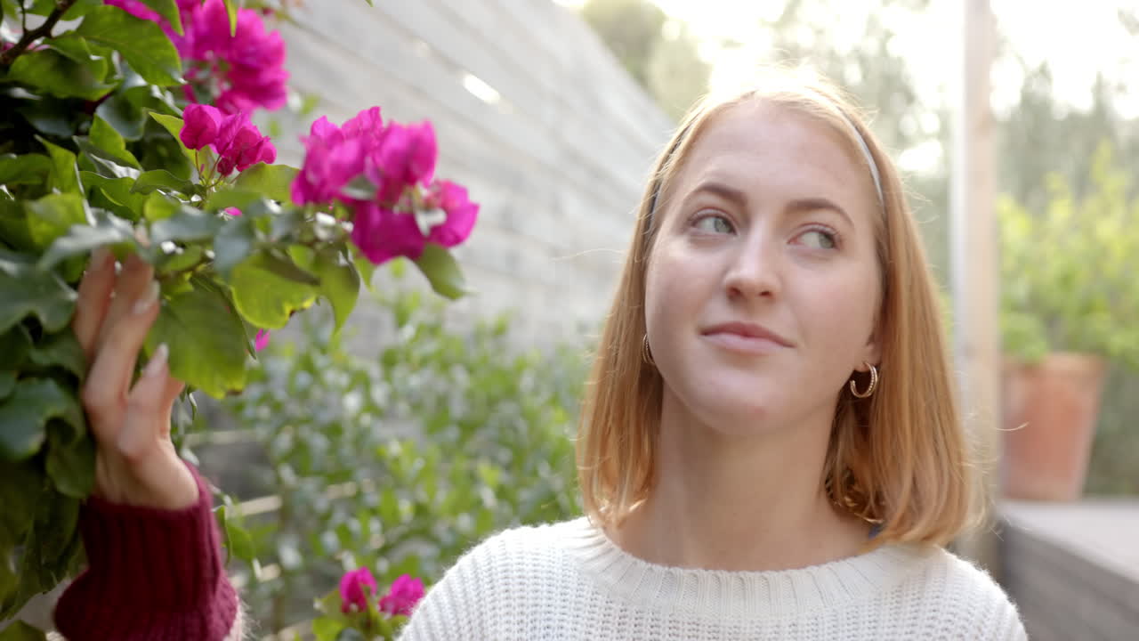 Woman admiring vibrant flowers in garden, enjoying peaceful outdoor moment