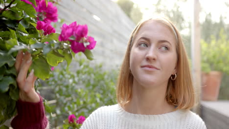 woman admiring vibrant flowers in garden, enjoying peaceful outdoor moment