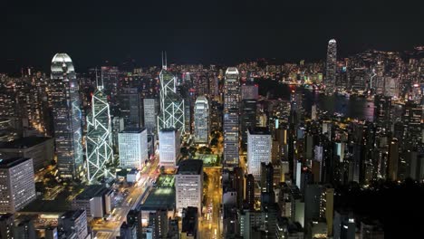 bright city lights illuminate the skyline of hong kong, showcasing a bustling urban environment. the towering buildings and waterfront create a captivating nighttime panorama.