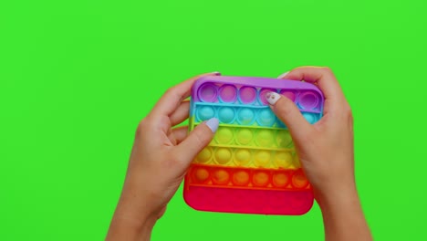 Close-up-of-girl-hands-playing-squeezing-anti-stress-toys-simple-dimple-game-isolated-on-chroma-key