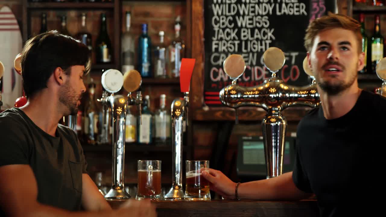 맥주 를 마시면서 흥분 된 친구 들 이 텔레비전 을 보고 있다