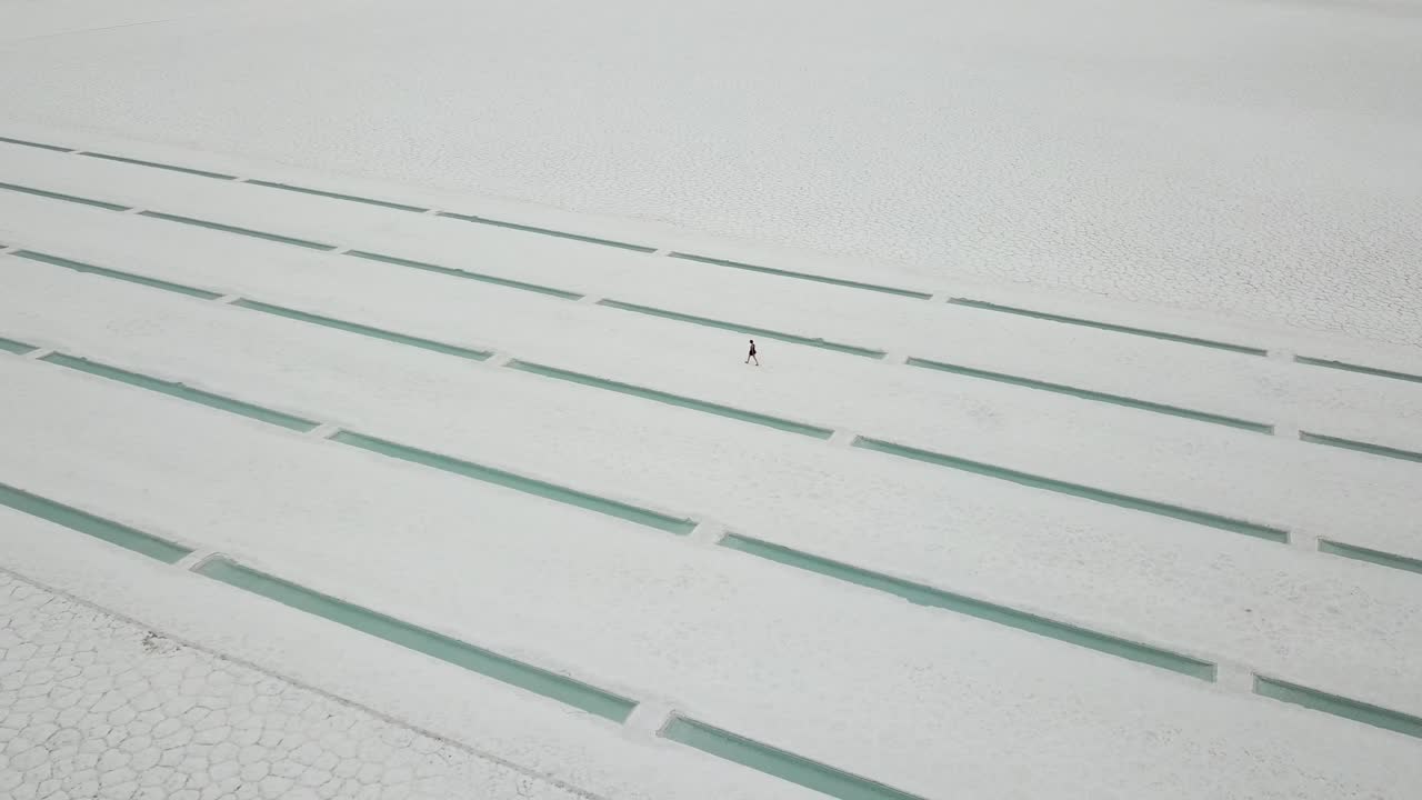Aerial View of Female Figure Walking on Salt Flat in Countryside of Argentina. Salinas Grandes, Jujuy Salta Region