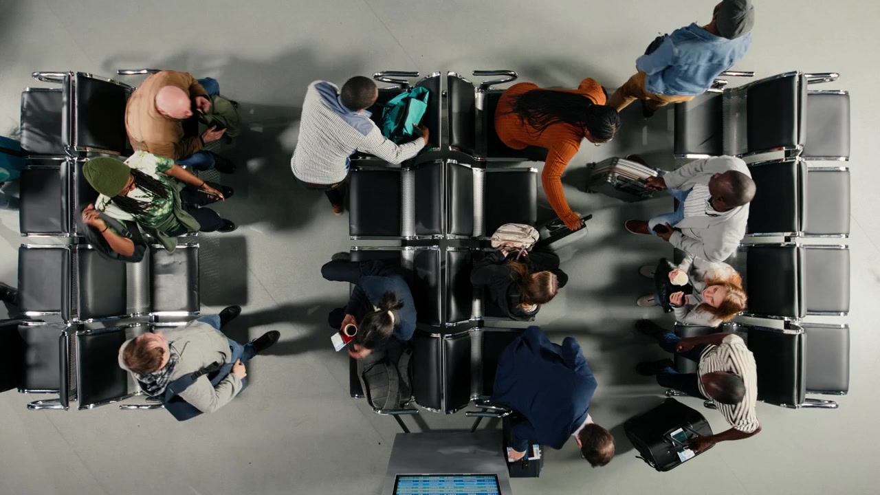 Top down view of tourists in airport lounge boarding for departing airplane flight