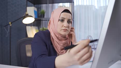 Office-worker-in-hijab-is-thoughtful.