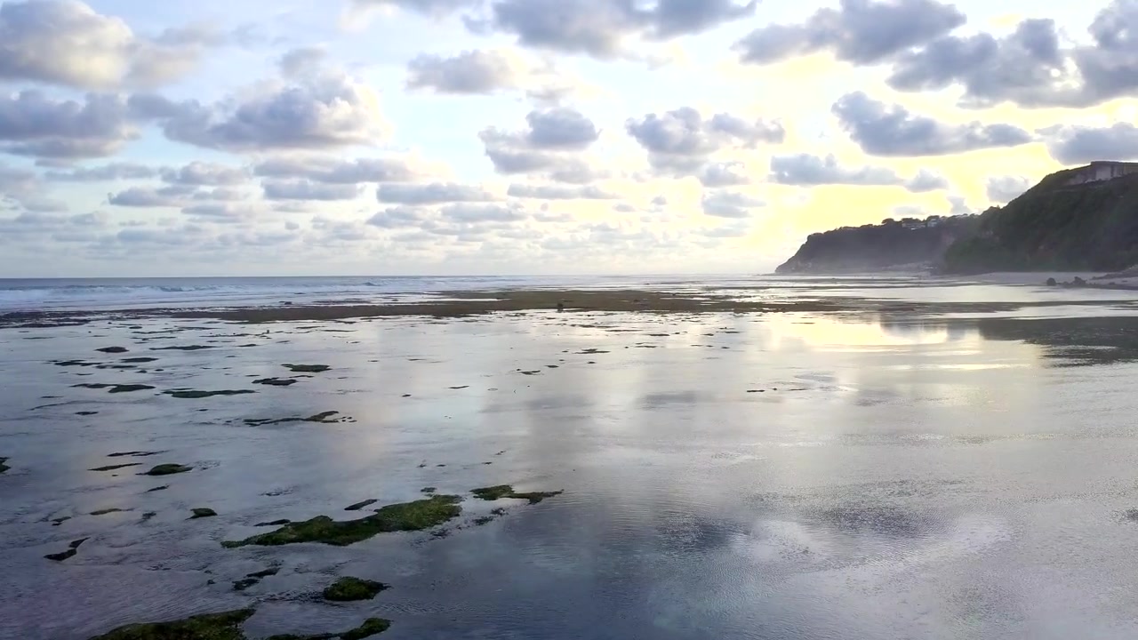 Vista aérea de recife de corais em uma ilha tropical com vista para as montanhas. Imagens de drone da praia de Bali. Conceito de vídeo de natureza e viagem