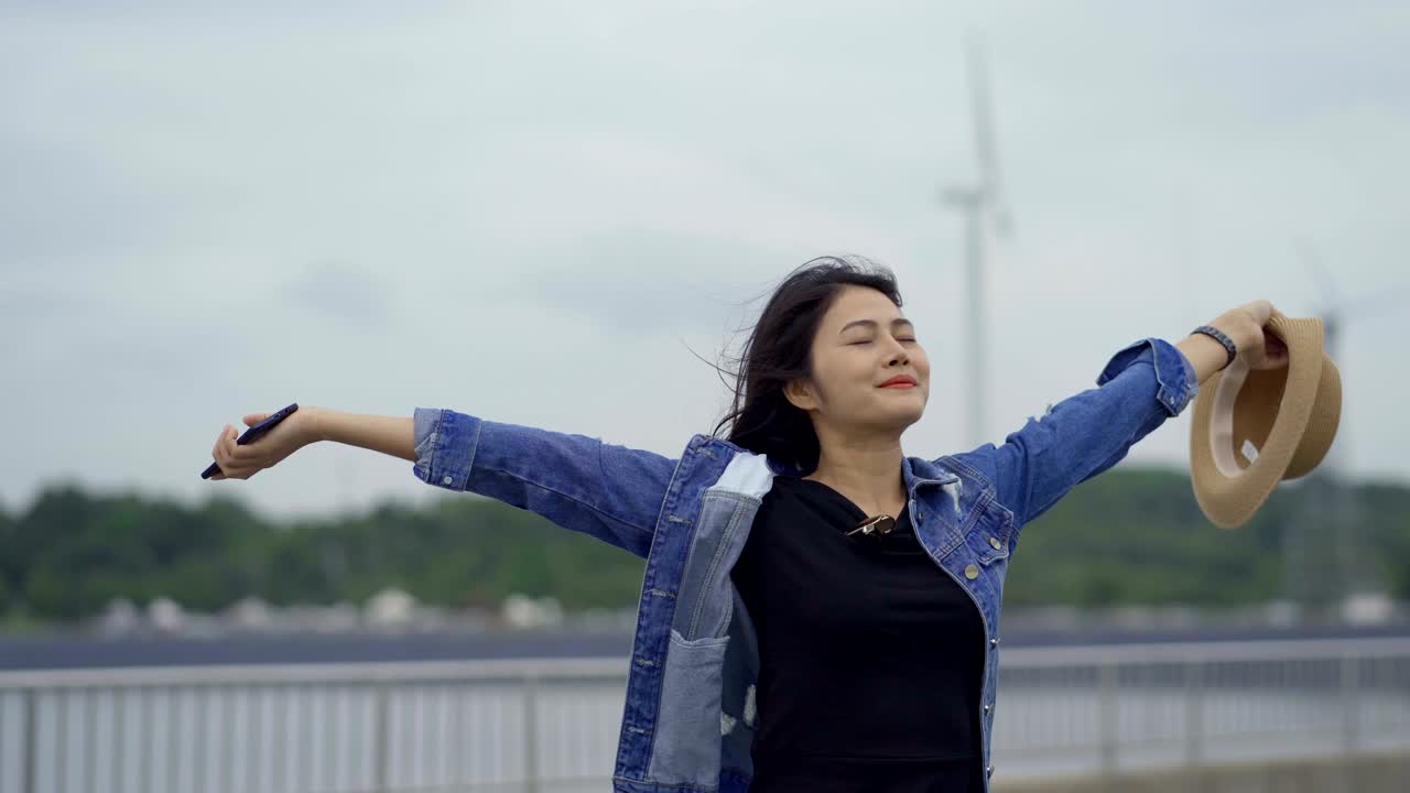 las mujeres asiáticas son felices verano despreocupado, sonriendo con los brazos levantados.