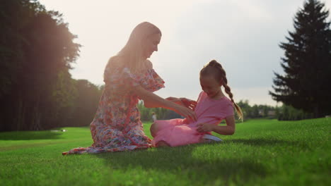 cheerful mother and daughter fooling outdoor. family playing in city park.