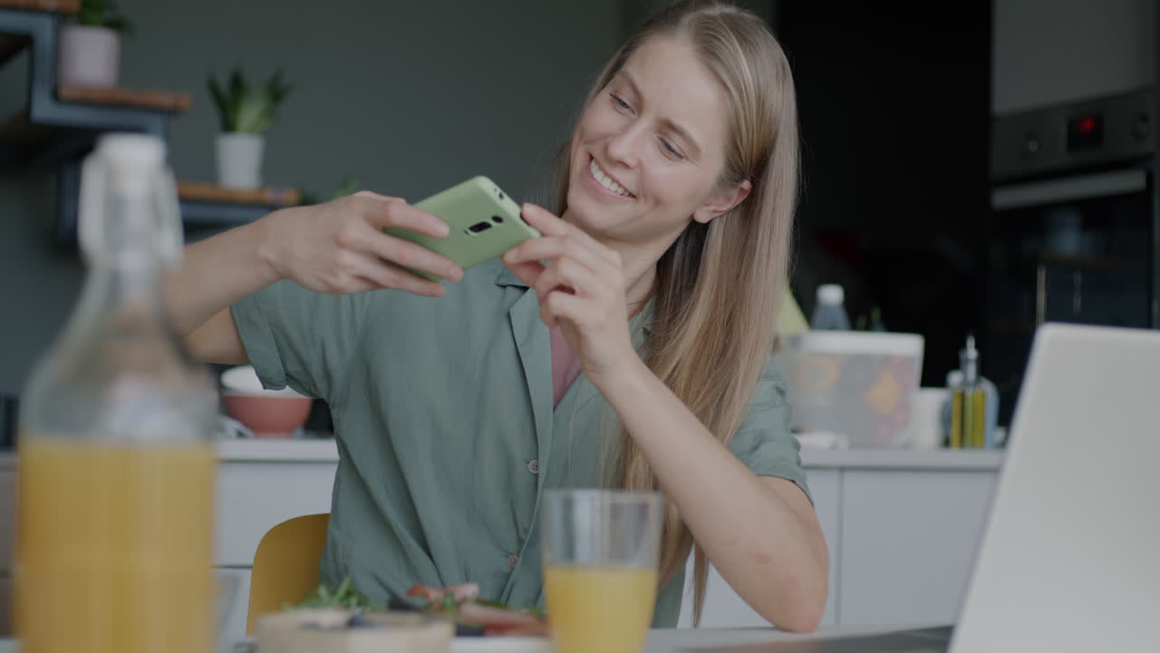 Woman taking photo of food in kitchen