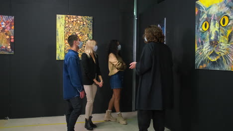 visitantes de exposiciones de arte que ven pinturas