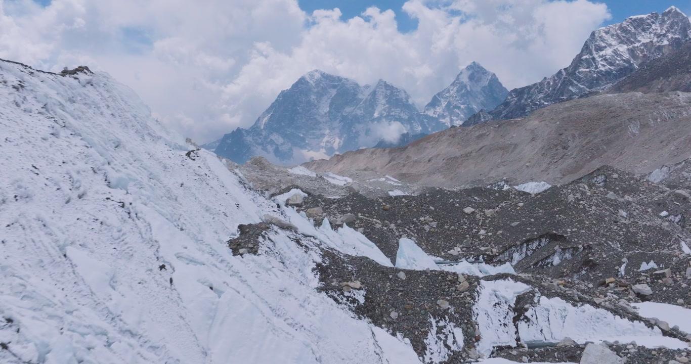 Drone shot of Khumbu Glacier at Everest Base Camp, Sagarmatha, Nepal. Snowy Himalayan peaks and ridges frame melting ice towers, glacier outburst risks, reflecting climate crisis impacts