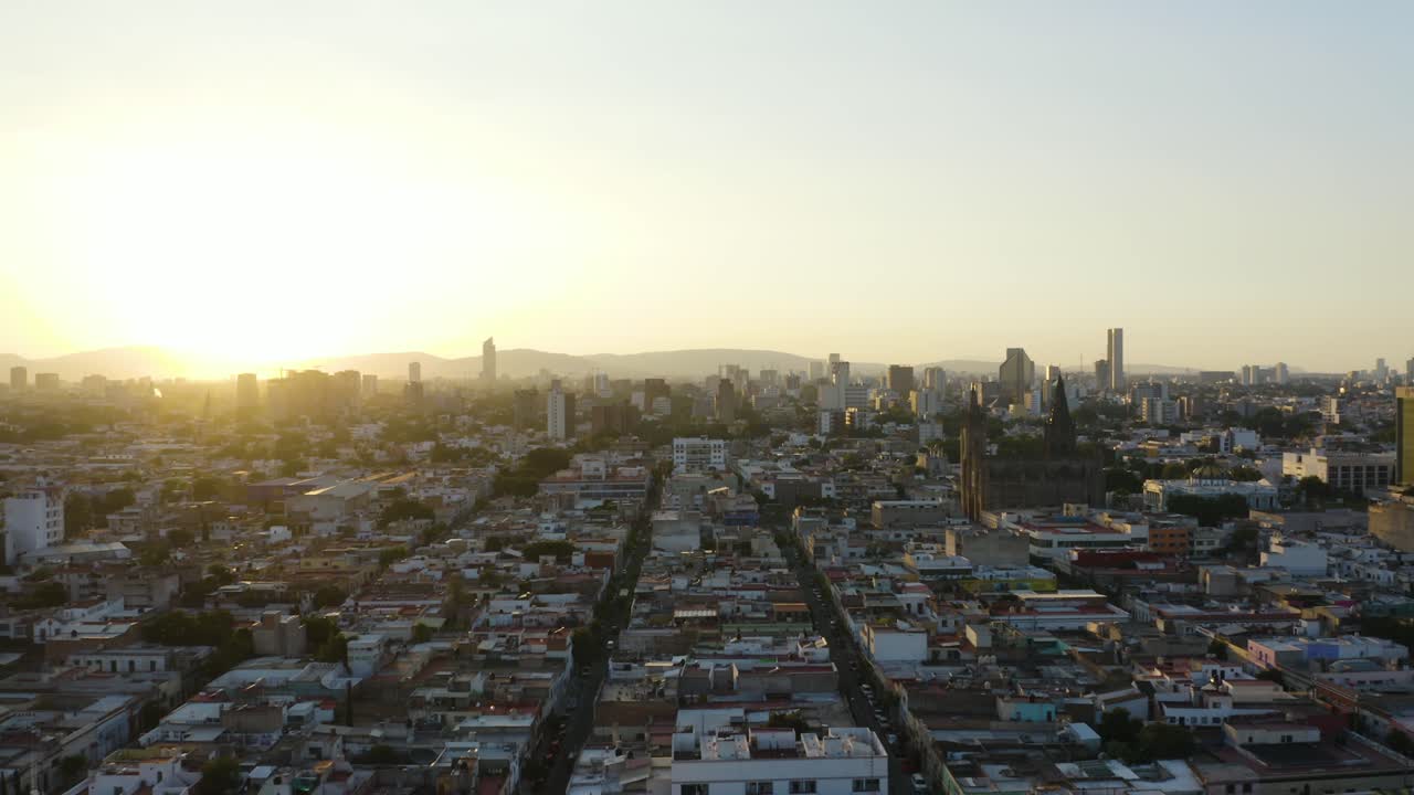 Il drone vola verso gli edifici moderni dello skyline di Guadalajara, Messico, al tramonto