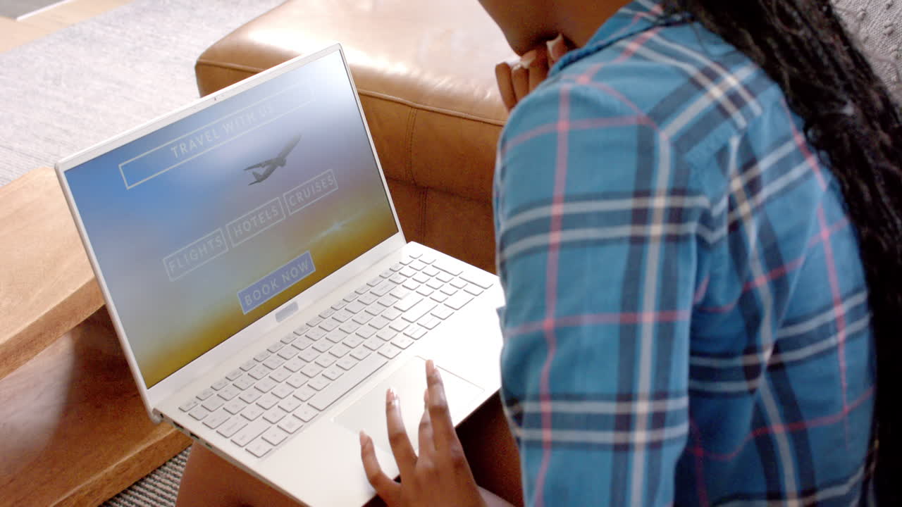 African American young woman wearing plaid shirt is booking travel