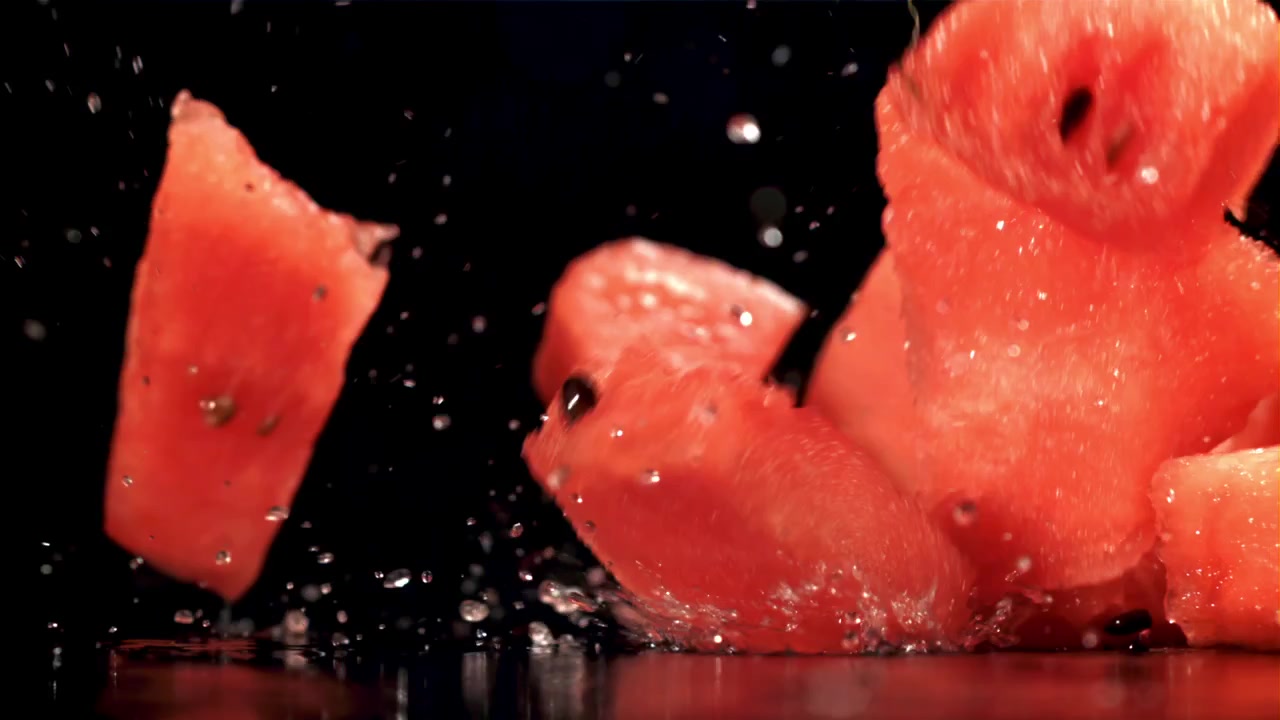 Friske vannmelonbiter som faller og plasker i sakte film