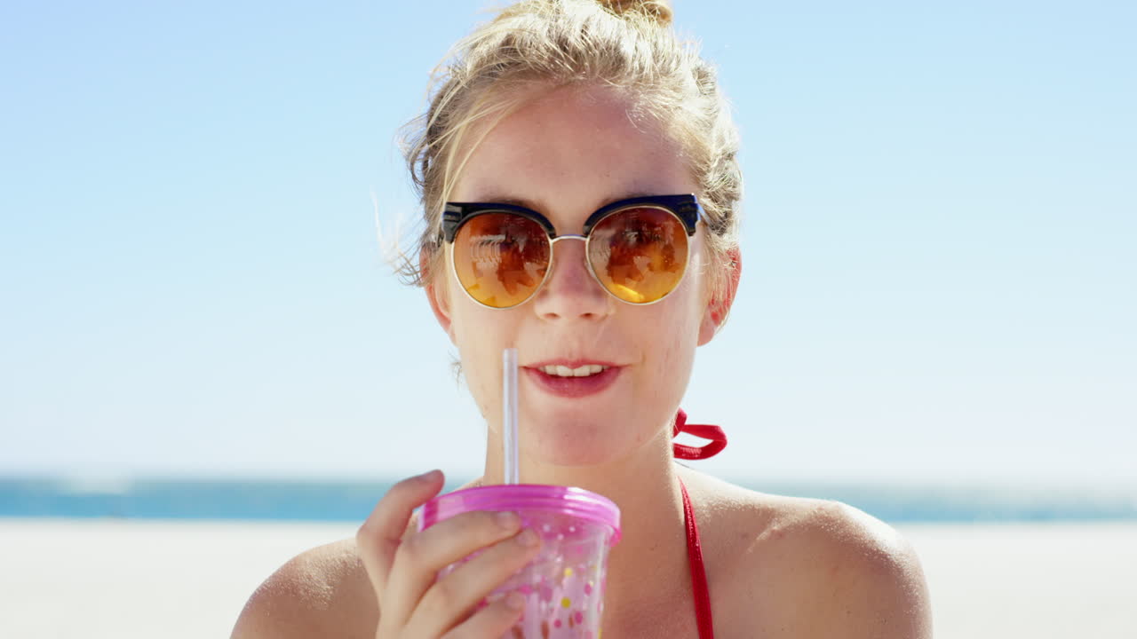 mujer disfrutando de una copa en la playa