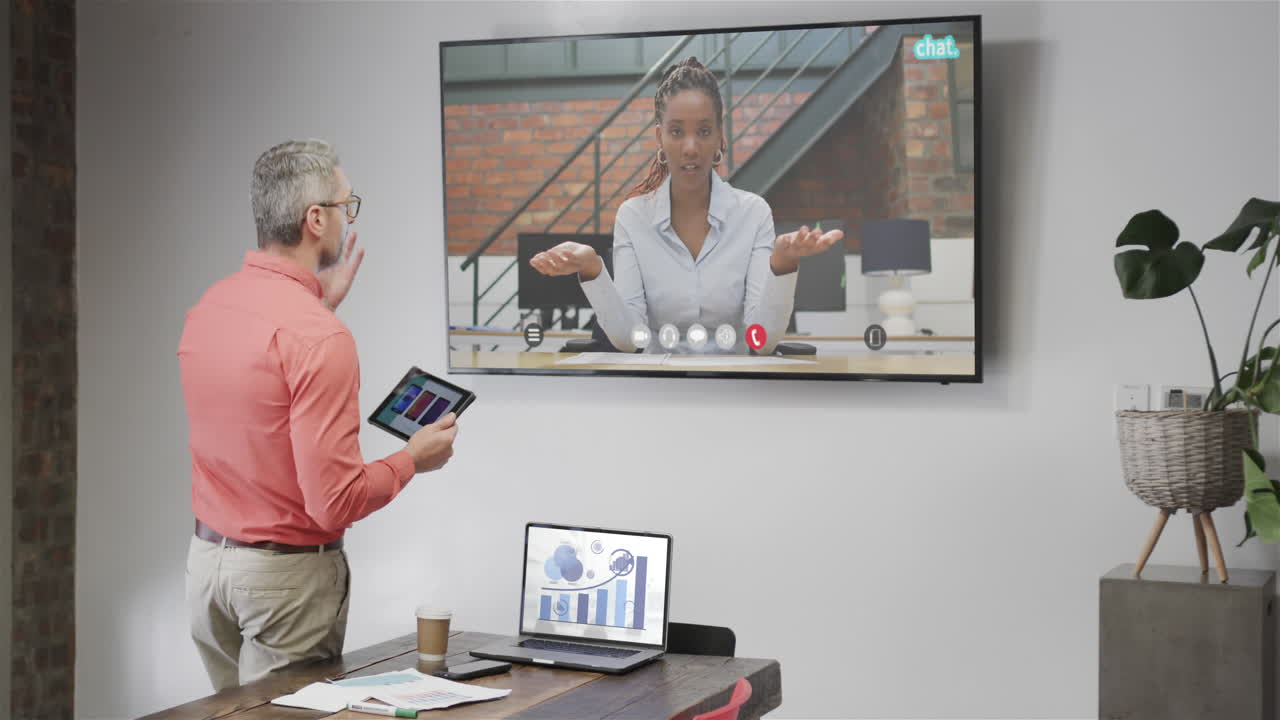Caucasian businessman on video call with african american female colleague on tv screen