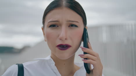 una mujer de negocios preocupada llamando por teléfono al aire libre de cerca. una mujer hablando con un teléfono inteligente.