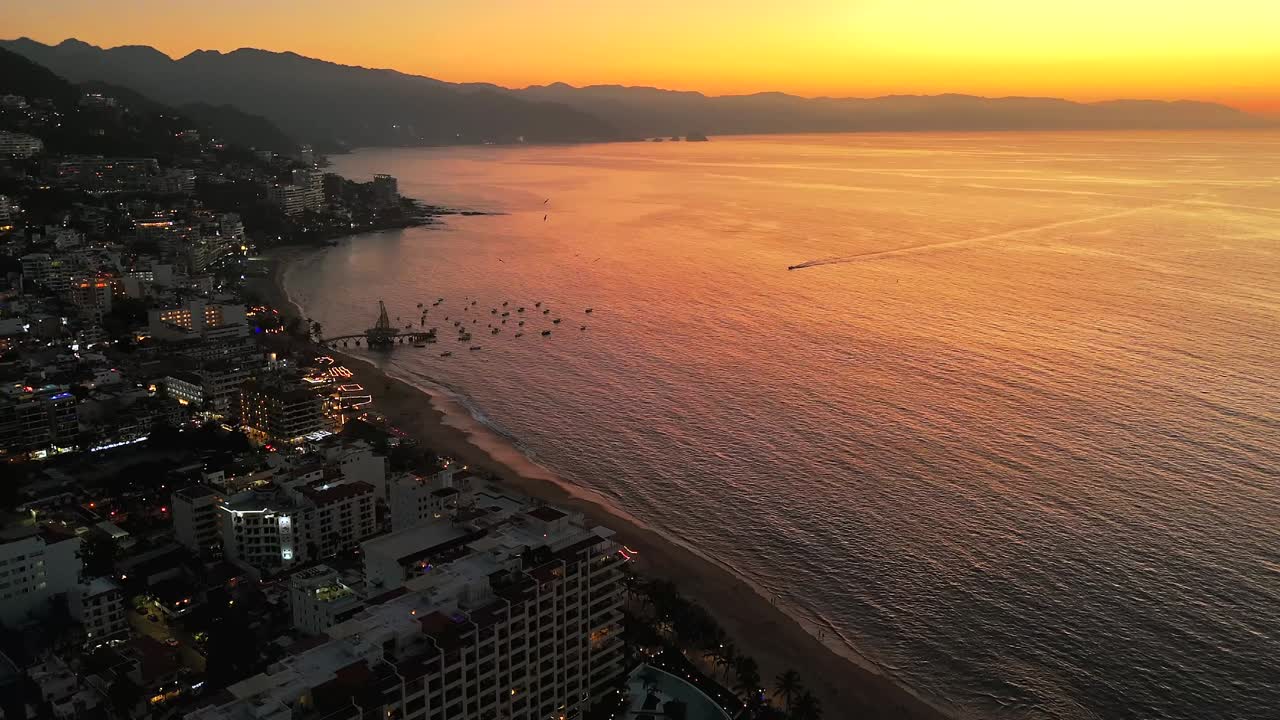 Dron 4K revelando la costa sur de Puerto Vallarta, mostrando un puerto, playas, malecón y laderas bajo la cálida luz del atardecer.