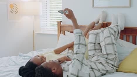 selfie, kiss and african couple on a bed