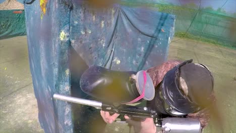 tiro pov de paintballer jugando en la arena al aire libre siendo golpeado por bolas de pintura, también golpeando la cámara