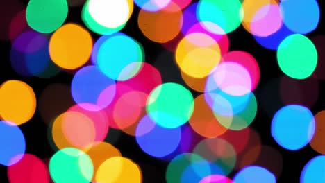 4k. estado de ánimo navideño, luces multicolores redondas y desenfocadas. hermoso salvapantallas de año nuevo. feliz felicitación navideña. fondo abstracto de guirnaldas brillantes por la noche. guirnalda navideña