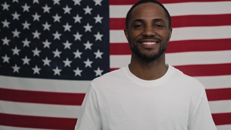 Video di uomo di colore allegro su sfondo con bandiera americana