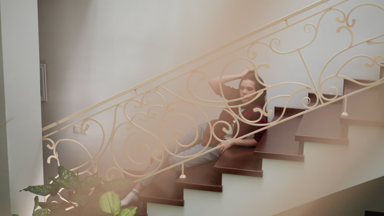 задумчивая женщина поцарапает голову на ступеньках. депрессивная женщина в обычной одежде преодолевает эмоциональный срыв, лежа на лестнице. психологические проблемы