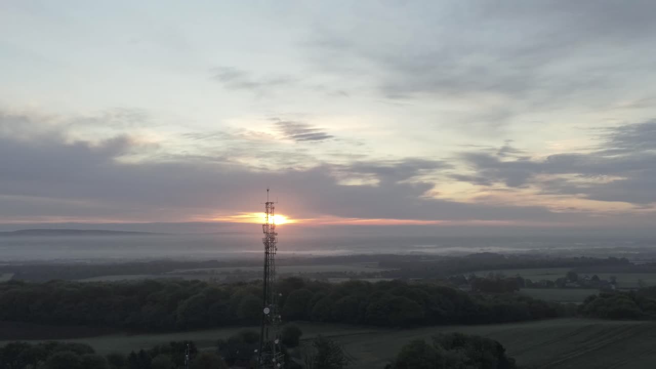 Early sunrise aerial moving down telecom towers on agricultural rural farmland countryside