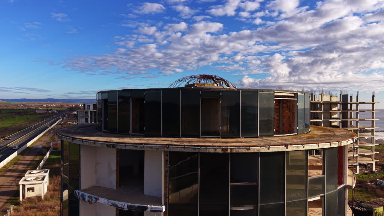 Design conico dell'edificio a molti piani con cupola in tondini di metallo in cima. Filmato da drone delle strutture nel cantiere.
