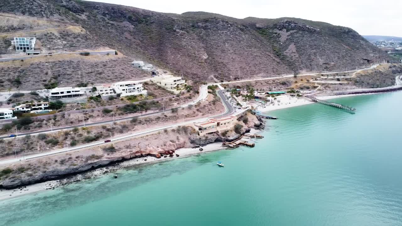 라 파즈 바야 캘리포니아 서 멕시코 근처의 해안선 인근의 플라야 엘 카이만시토의 공중 전망 바다의 바쁜 도로의 전망과 함께 건물과 함께 바위 풍경