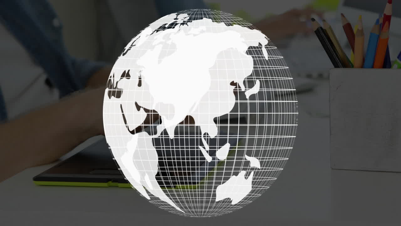 Rotating globe animation over person using tablet at desk with pencils