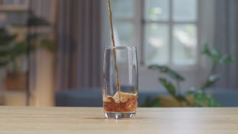 cola fresca que se vierte en el vaso en la mesa