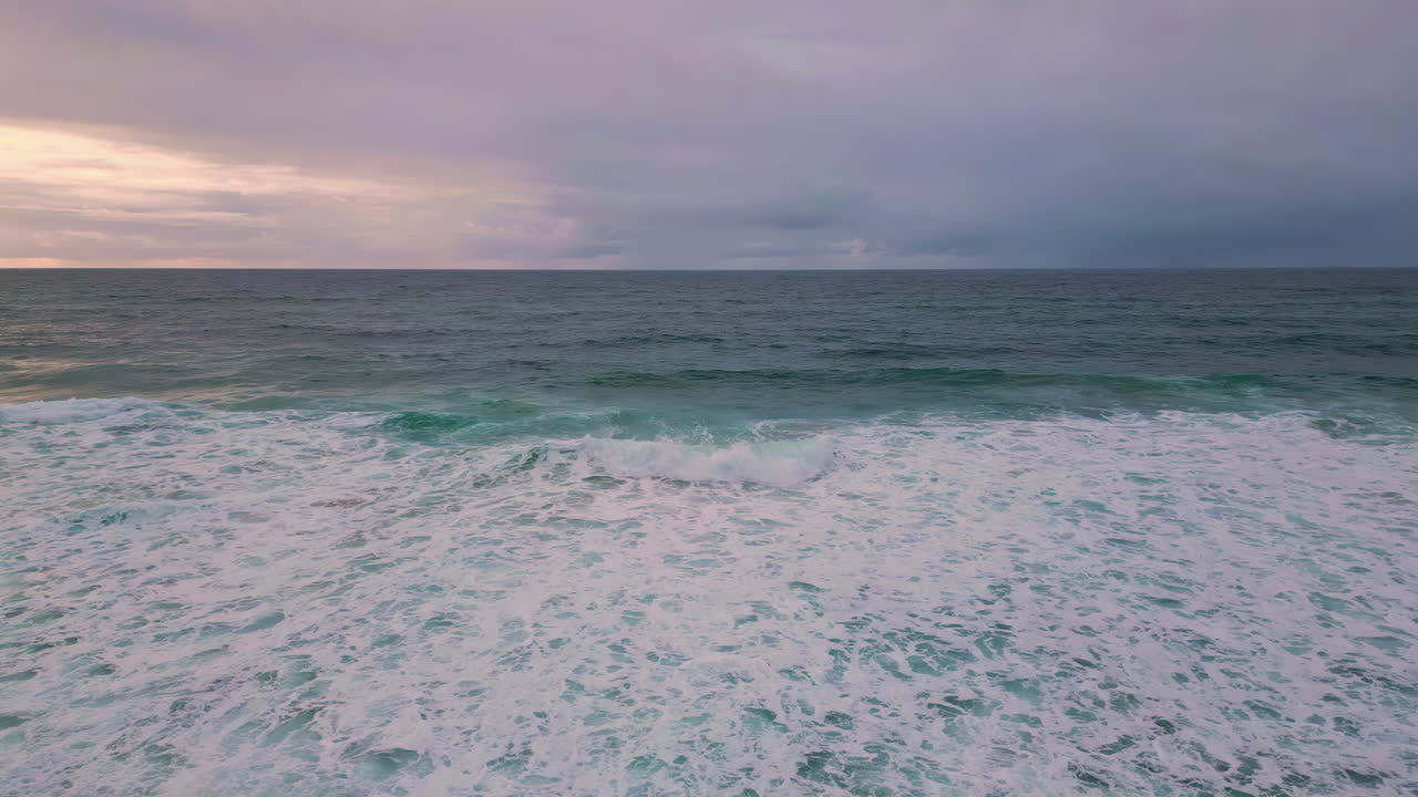 Foamy waves crashing shoreline at tranquil twilight aerial view. Ocean force