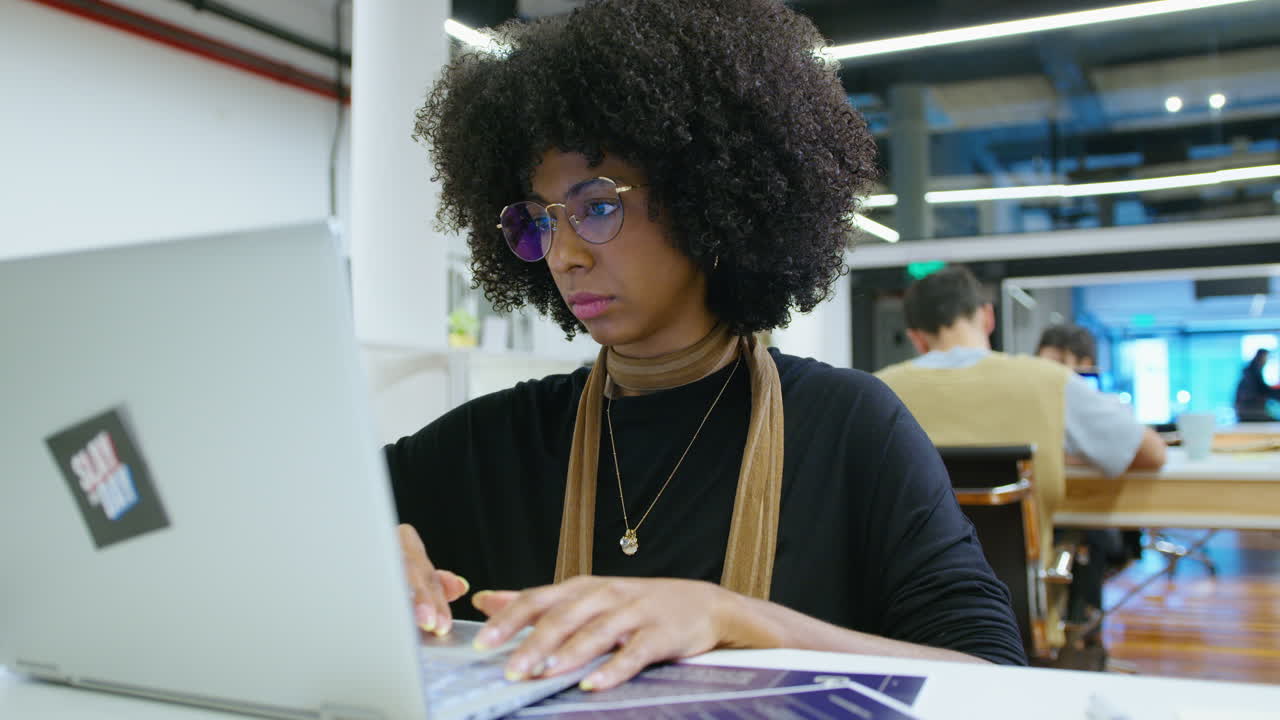 Young African-American Businesswoman Using Laptop at Desk in the Office