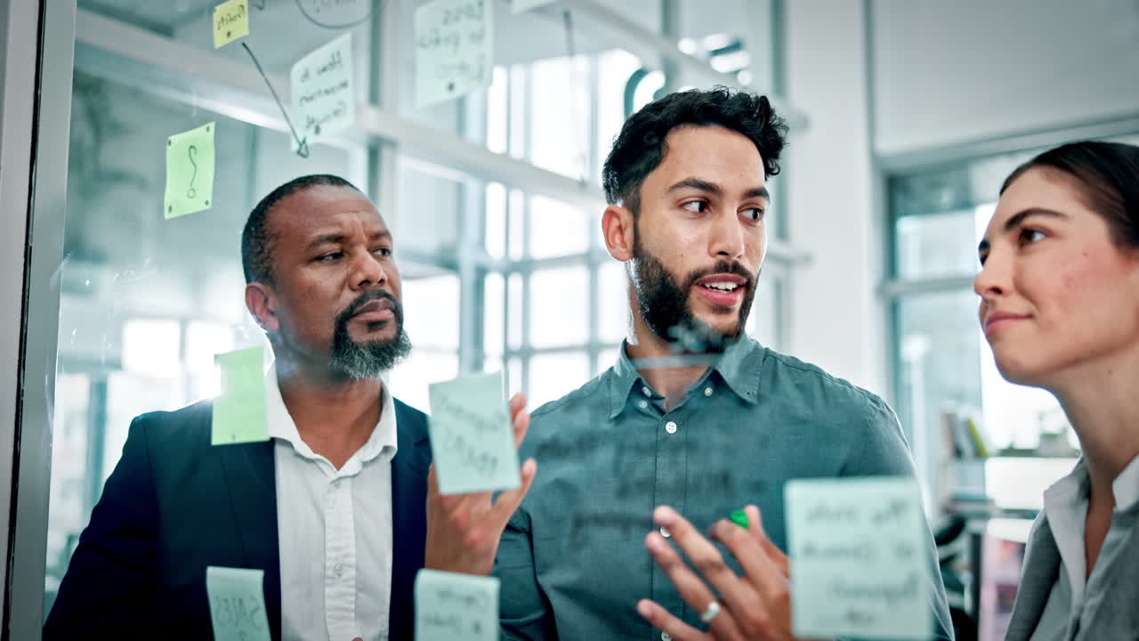 Diverse Business Team Brainstorming Ideas on a Glass Board