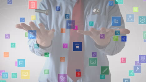 animation of network of colourful icons floating over businessman throwing and catching nut and bolt