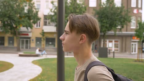 close-up side walking camera shot of teenage boy walking in the city