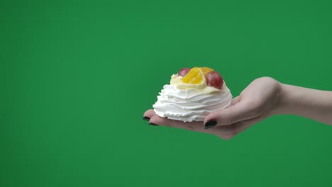 hand holding a fruit pavlova