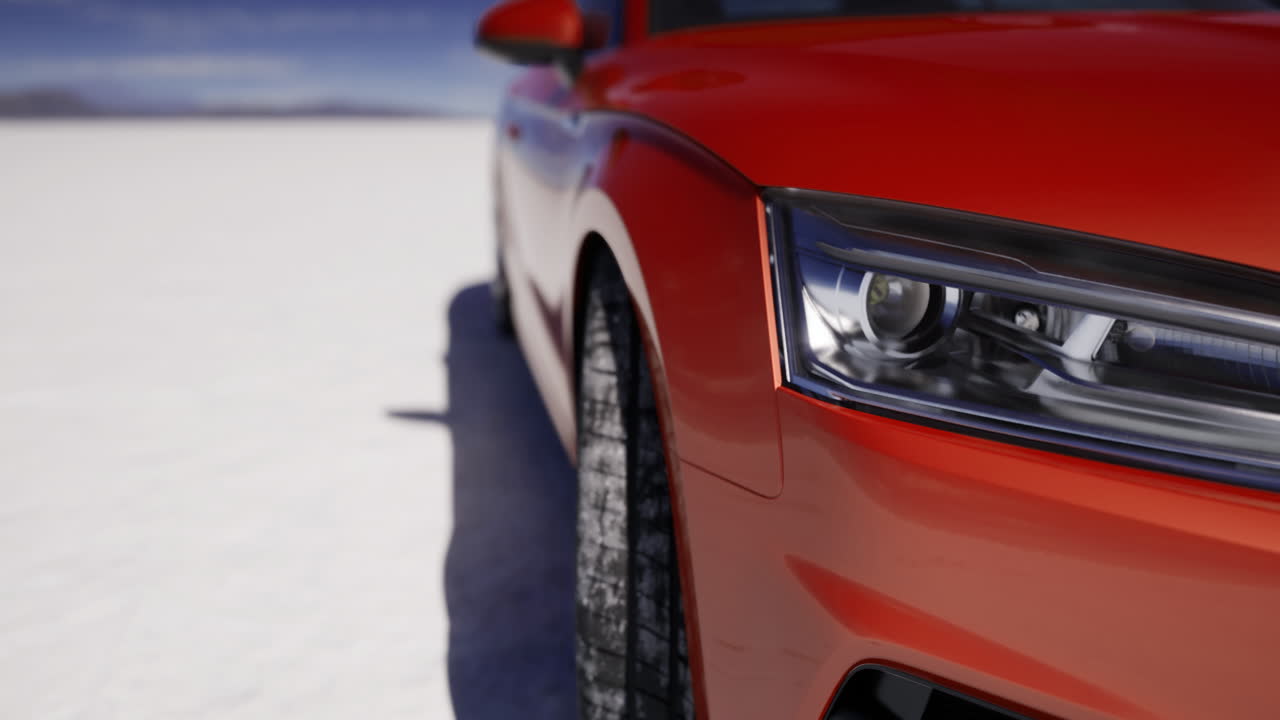 Bright red car parked on a snowy surface under a clear blue sky