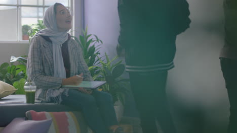 young muslim business woman using digital tablet computer 3d artist drawing graphic design on mobile touchscreen device screen sharing ideas with colleague in diverse office