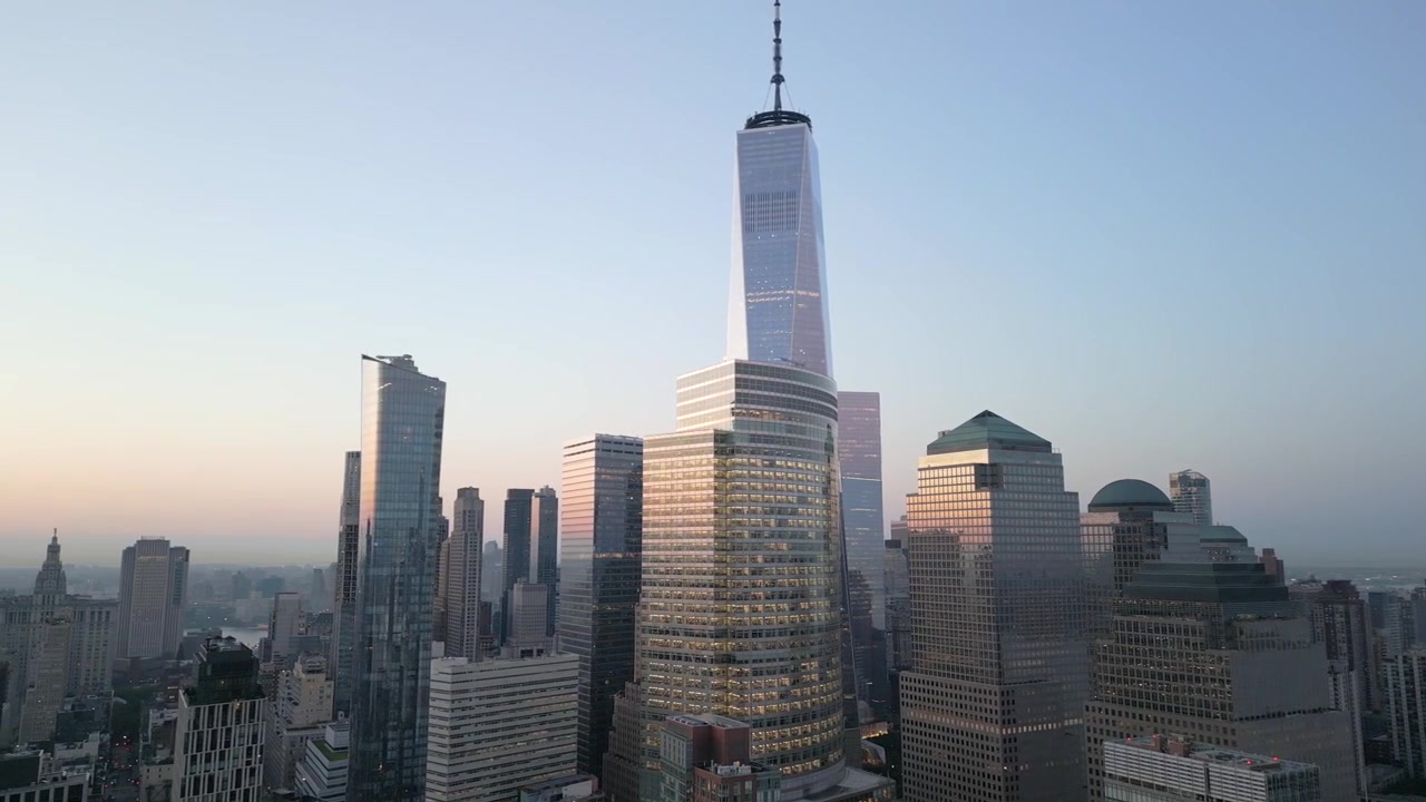 Cidade de Nova Iorque, Manhattan, distrito financeiro do One World Trade Center, tomada aérea de drone, com inclinação para o horizonte de Downtown ao nascer do sol, o sol refletindo nas janelas na hora dourada em 4K 60 fps
