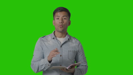 male teacher talking to school university or college class in lesson against green screen