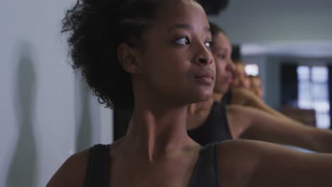 multi-ethnic group of fit female modern dancers practicing a dance routine